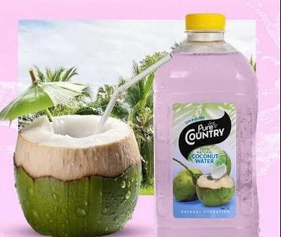 Pink-toned Pure Country coconut water beside a fresh coconut